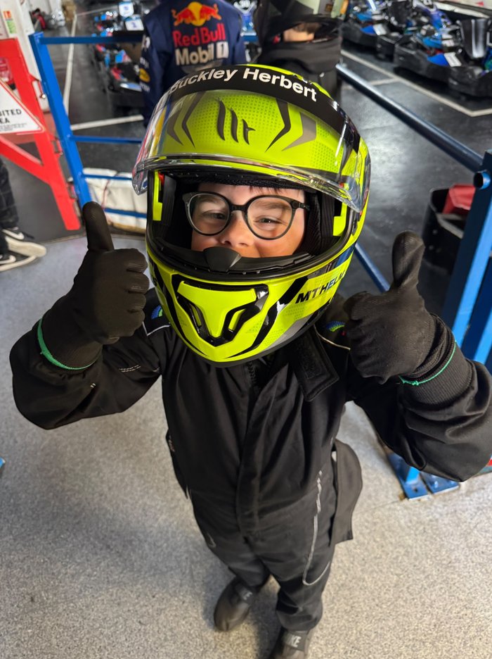 Buckley Herbert giving a thumbs up in his racing suit and helmet after his first race win at Anglia Karting