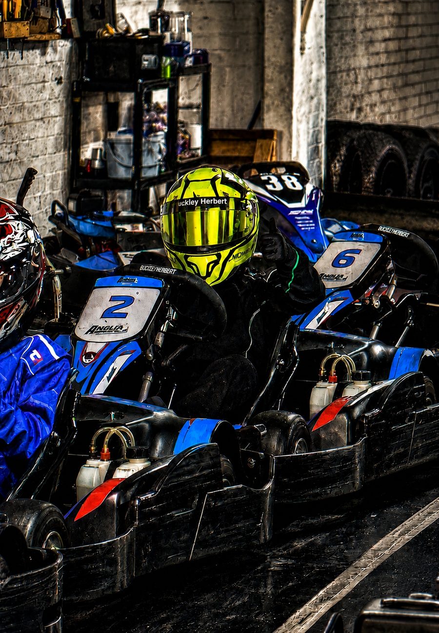 Karting drivers in the pit lane preparing for a session